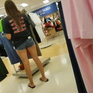 Girl With Stocky Legs in Denim Shorts and Slippers - Candid Photo at the Store