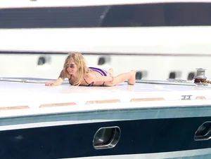 Avril Lavinge looking sexy in purple bikini on a boat