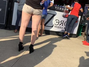 Bunch of girls in various outfits at a Cardinals baseball game