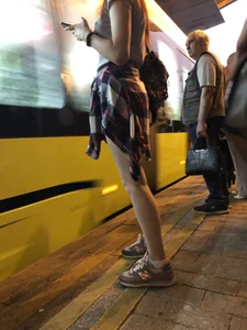 Cute Teen in Shorts on the Tram Stop
