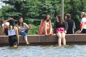 Young College Girls in Dresses, Skirts And Pantyhose Having a Good Time By the City Fountain
