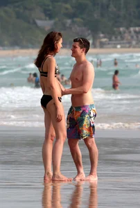 Babe in black bikini on the beach with her boyfriend