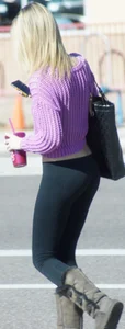 Beautiful skinny blonde in tight leggings and purple crop top showing sexy stomach