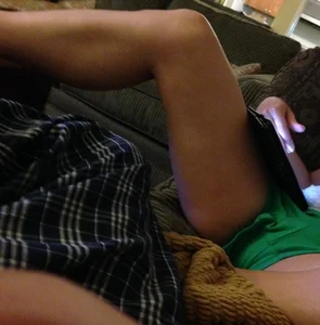Girl in mini shorts sitting on the couch spreading her legs