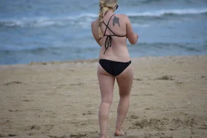 Chunky blonde in a black bikini on the beach