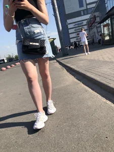 A very cute street candid girl wearing a denim fringed skirt passing by, great legs