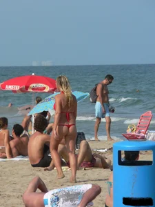 Sexy mom and daughter in red thongs at the beach
