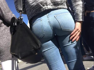 Sexy Round Bubble Ass in Tight Blue Jeans on the Street Closeup - Girl Touching Her Butt Cheek