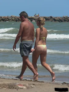 Sexy blonde on the beach in a yellow thong bikini