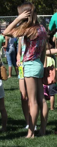 Brunette skinny teen in green shorts playing in a bounce house