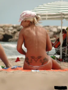 Tattooed blonde with big tits topless and in thong