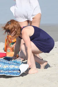 Pale redhead girl with thick booty and flat chest on the beach in her bikini