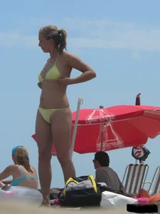 Sexy blonde on the beach in a yellow thong bikini