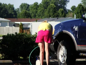 Group of cute girls at a car wash in bikinis and shorts