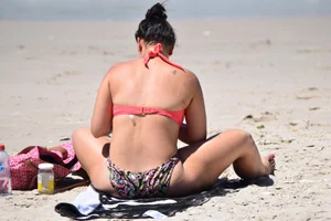 Huge boobed thick brunette babe on the beach in a bikini