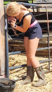 Very cute non-candid blonde teen with a cow