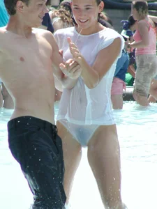 Candid young candid girl in wet panties and T-shirt playing in fountain