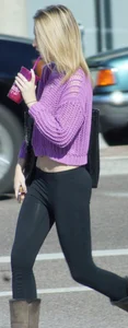 Beautiful skinny blonde in tight leggings and purple crop top showing sexy stomach