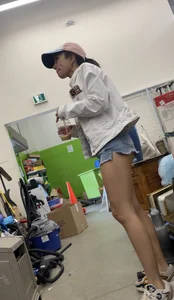 Tight bum hanging out of jean shorts in thrift shop