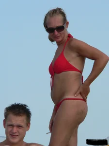 Sexy mom and daughter in red thongs at the beach