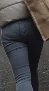 Girl with a tight ass in grey jeans going up the escalator