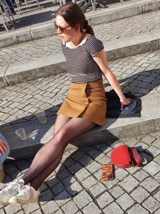 Candid legs in black pantyhose, girl in a skirt sitting on a step on the street creepshot