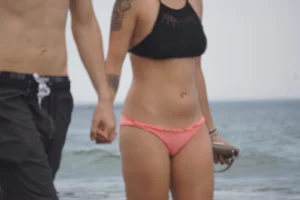 Peach bikini tattood babe on the beach with a nice ass and some camel toe