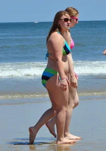 Two beach friends in bikinis one with back dimples and the other thick