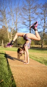 Non-candid gymnast teen showing off her stretch while wearing rollerblades and a leotard in the park