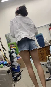 Tight bum hanging out of jean shorts in thrift shop
