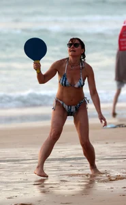 Older lady playing on the beach in her bikini