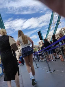 Skinny blonde girl wearing a short skirt with long slim legs street creepshots