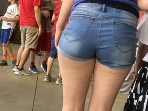 Bunch of girls in various outfits at a Cardinals baseball game