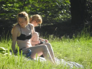 Two sexy friends in black bikinis laying out