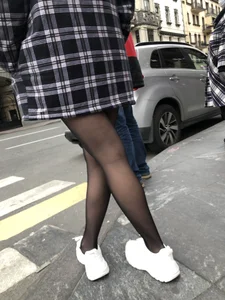 Cute candid girl with legs in black pantyhose waiting on the crosswalk