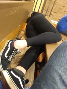 Teen girl wearing leggings laying on the bench