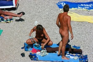 Nudist couple on the beach, girl has amazing tits and nice ass in a thong