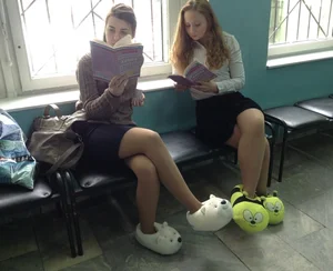 College Teens in Skirts, Pantyhose And Funny Furry Slippers Sitting And Reading