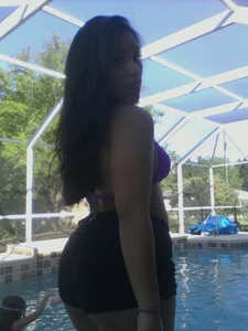 Cute non-candid teen girl in a swimsuit and shorts by the pool