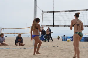 Sexy beach volleyball girl in sport bra top with pokies and blue bikini bottom