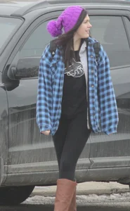 A cute brunette in leggings boots and hat