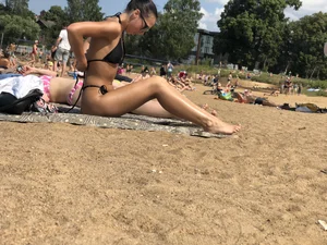 Gorgeous milf rubbing sun lotion in her skin at the beach, with a couple of her milf friends