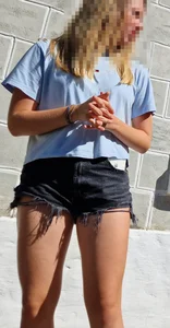AMAZING detailed creepshot of a blonde girl wearing black fringed jean shorts, thin light hair oh her legs