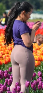Cute babe in tight leggings taking pictures in flower fields