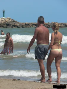 Sexy blonde on the beach in a yellow thong bikini