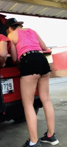 Girl showing her ass cheeks at her car in black shorts