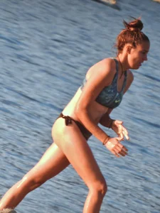 Sexy beach girl in a Nike sports bra and black bikini bottom