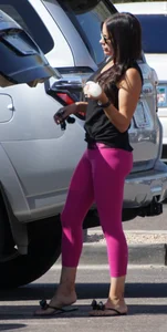 Milf brunette in purplish-pink leggings looking sexy in the parking lot