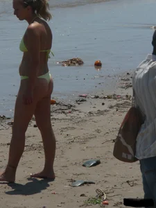 Sexy blonde on the beach in a yellow thong bikini