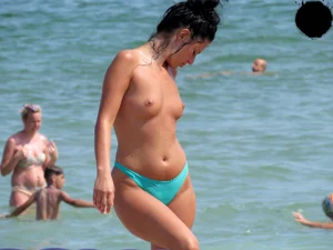 Brunette topless babe with cute tits and a nice ass in a thong bikini